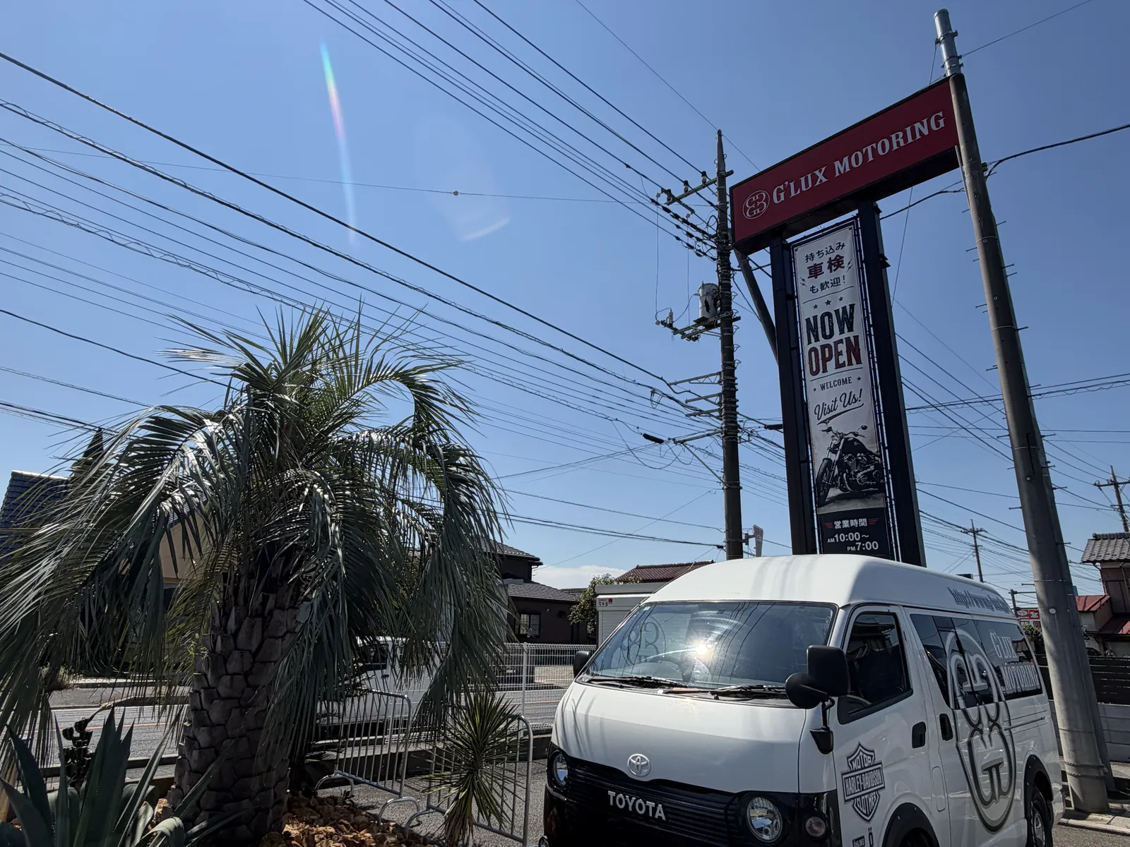 送迎用のハイエースと道路沿いの看板