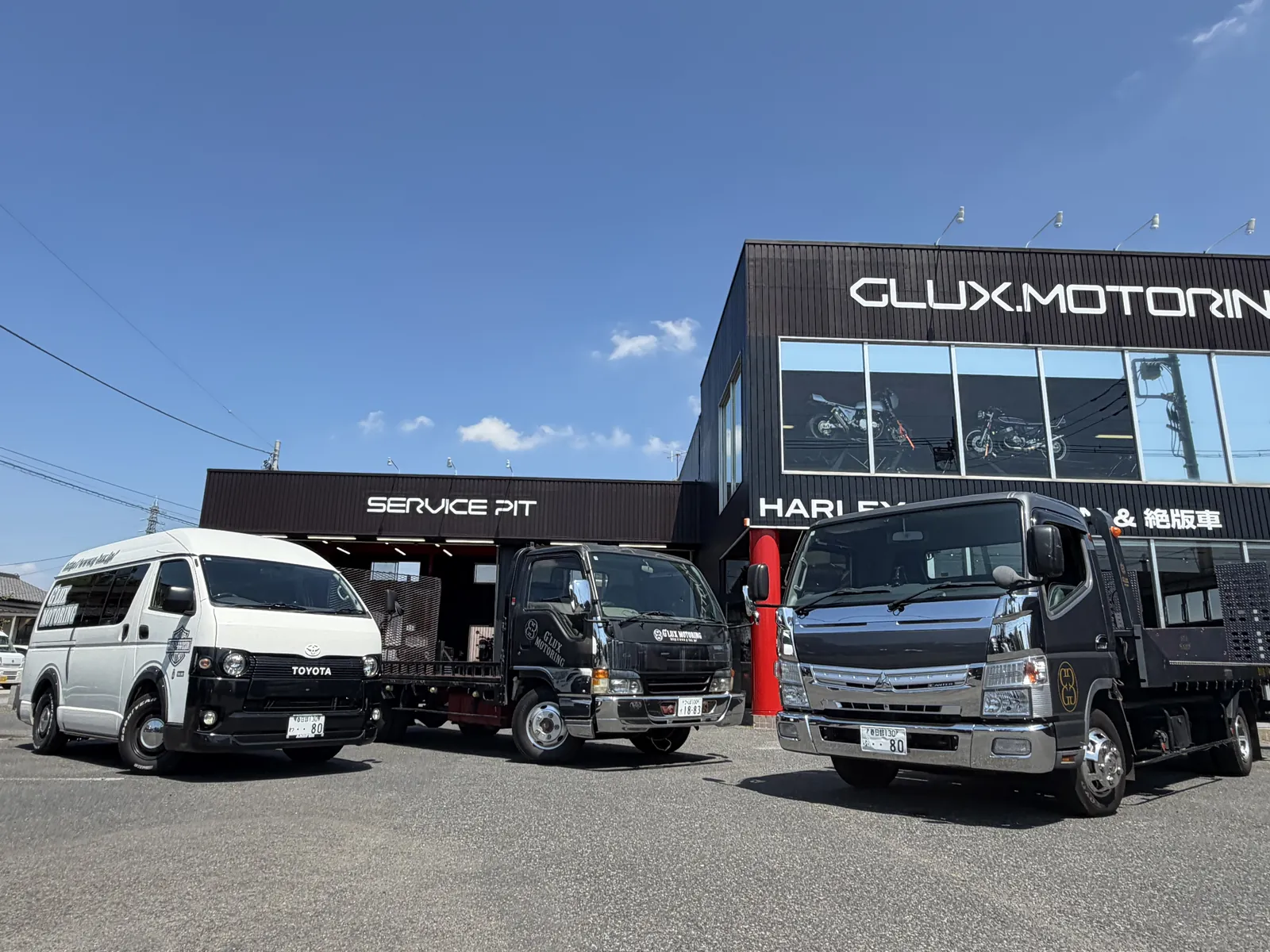 店舗前に並ぶハイエースと自社積載車2台